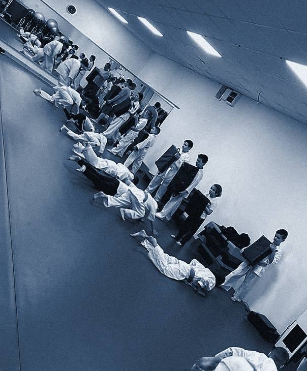 A klub küzdősport-szőnyege, rajta edzésen álló csoport távolról